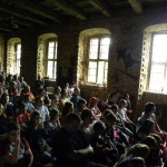 Uczestnicy siedzą na sali w zamku