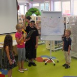 Dzieci na flipcharcie prezentują swoją pracę