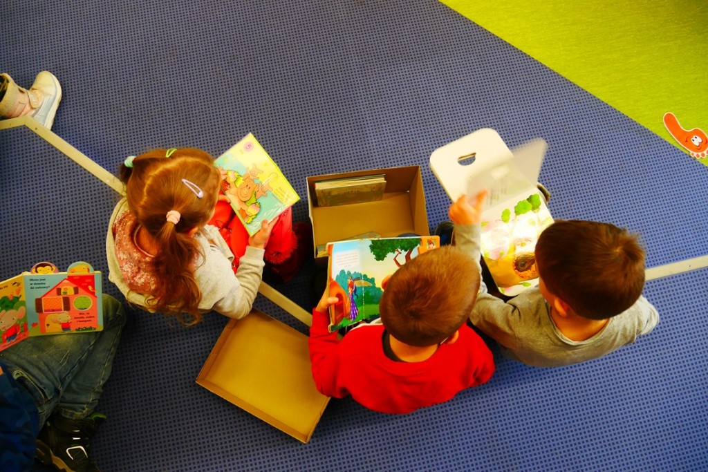 Dzieci wyciągają książki z pudełek i je oglądają