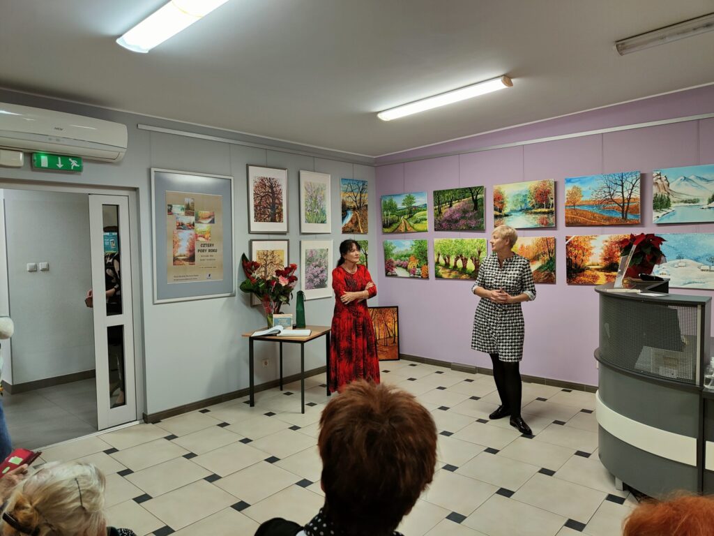 widok na dwie kobiety stojące na tle galerii obrazów