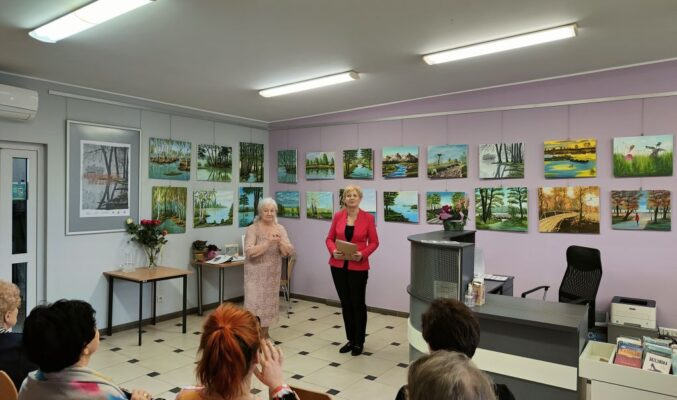 dwie kobiety stoją na tle galerii obrazów